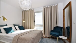 A bedroom with a bed, a chair, a small table, a large mirror, and a view of the outdoors. - Ref: 240  Modern beautiful apartment with amazing sea views (Fuengirola)
