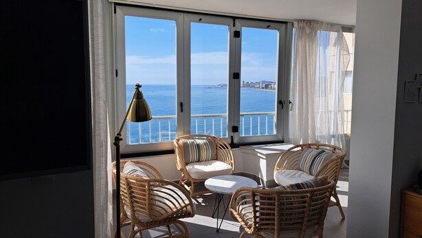 A balcony with wicker chairs and a table, overlooking a city and the sea. - Ref: 240  Modern beautiful apartment with amazing sea views (Fuengirola)