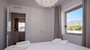 A hotel room with a bed, a wardrobe, a bathroom, and a window with a city view. - Ref: 307 Modern beachfront apartment in Torreblanca with stunning sea views (Fuengirola)