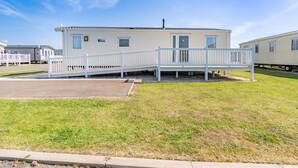 A mobile home with a small deck and a covered porch. - Gold Caravan 6 WCF (Pet) (Skegness)