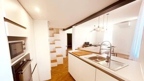 Une cuisine moderne équipée d’un four à micro-ondes, d’un four traditionnel et d’un évier.