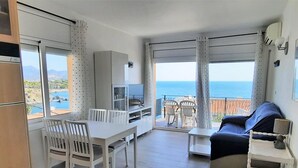 Un appartement moderne doté d’un balcon, d’un coin repas, d’un canapé et d’une télévision.