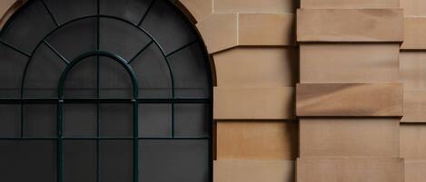 A building facade with a large arched window and stone masonry.