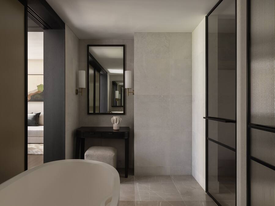 Ein modernes Badezimmer mit Badewanne, Waschtisch und Spiegel sowie einem großen Fenster.