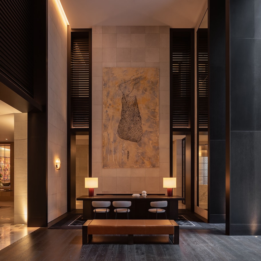 A lobby with a reception desk, seating area, and a large abstract painting.