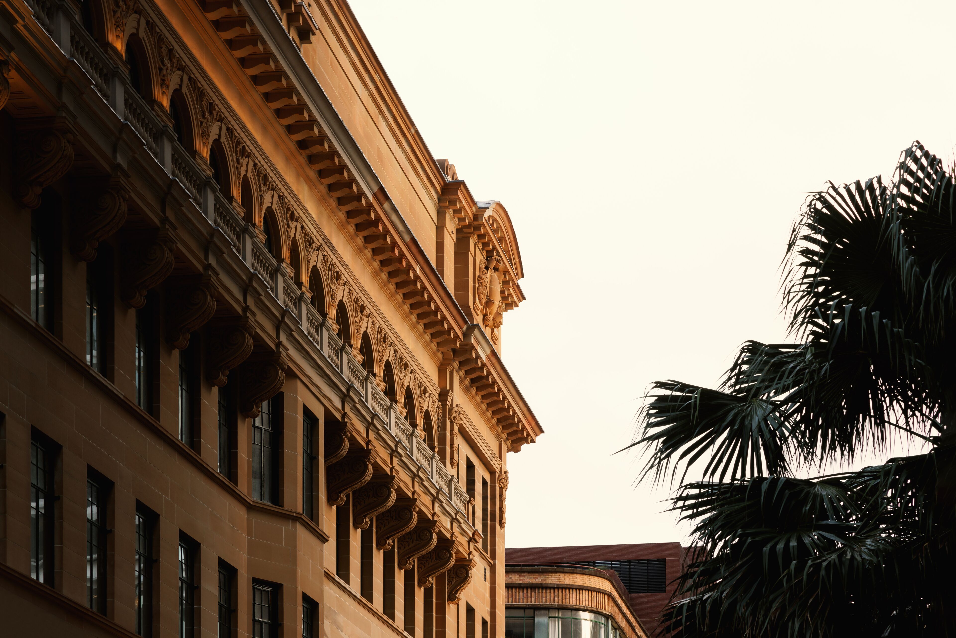 Un edificio con detalles arquitectónicos clásicos, incluyendo ventanas en arco y molduras decorativas.