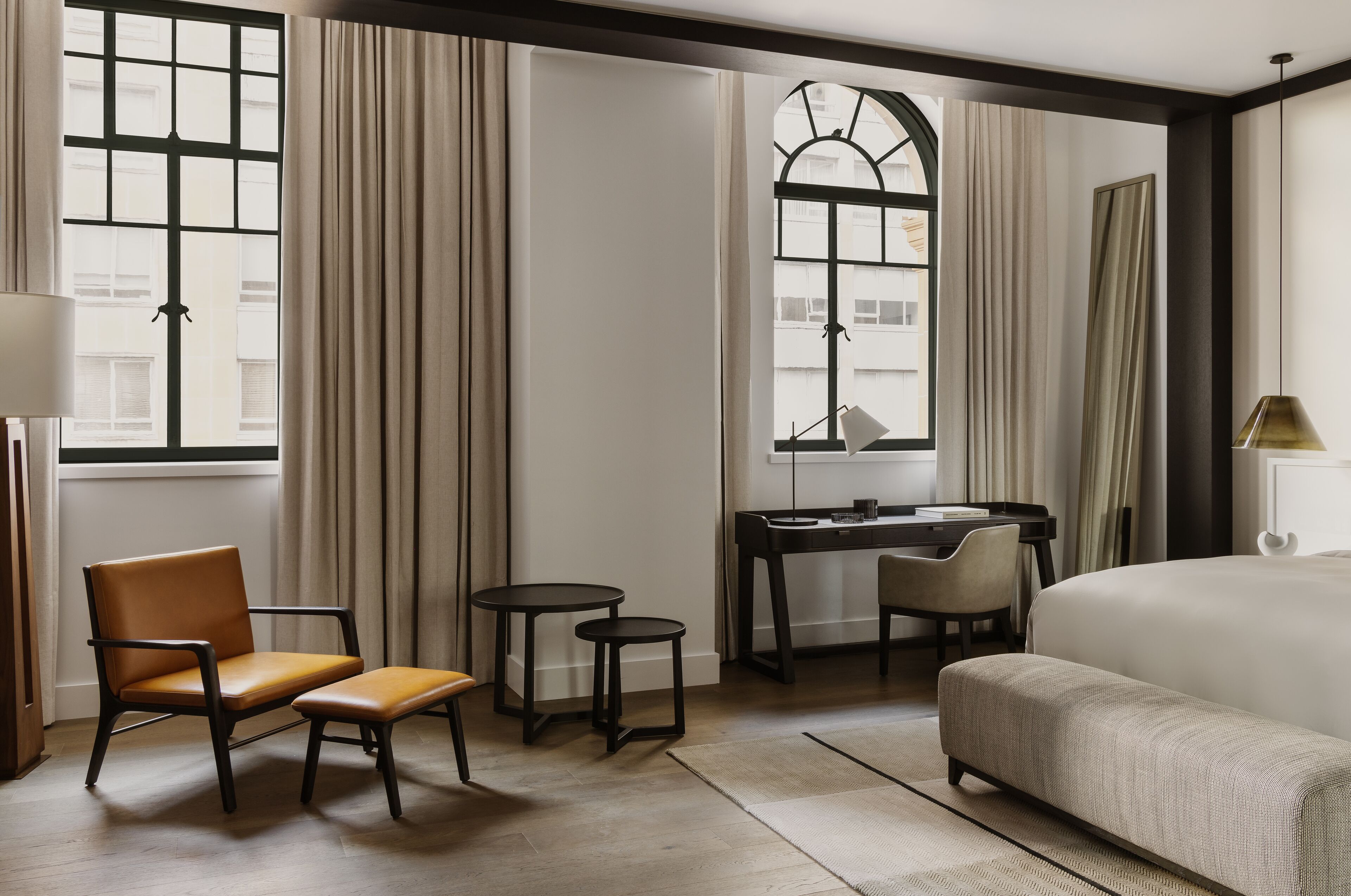 Habitación de hotel con cama, escritorio, dos sillas y una mesita.