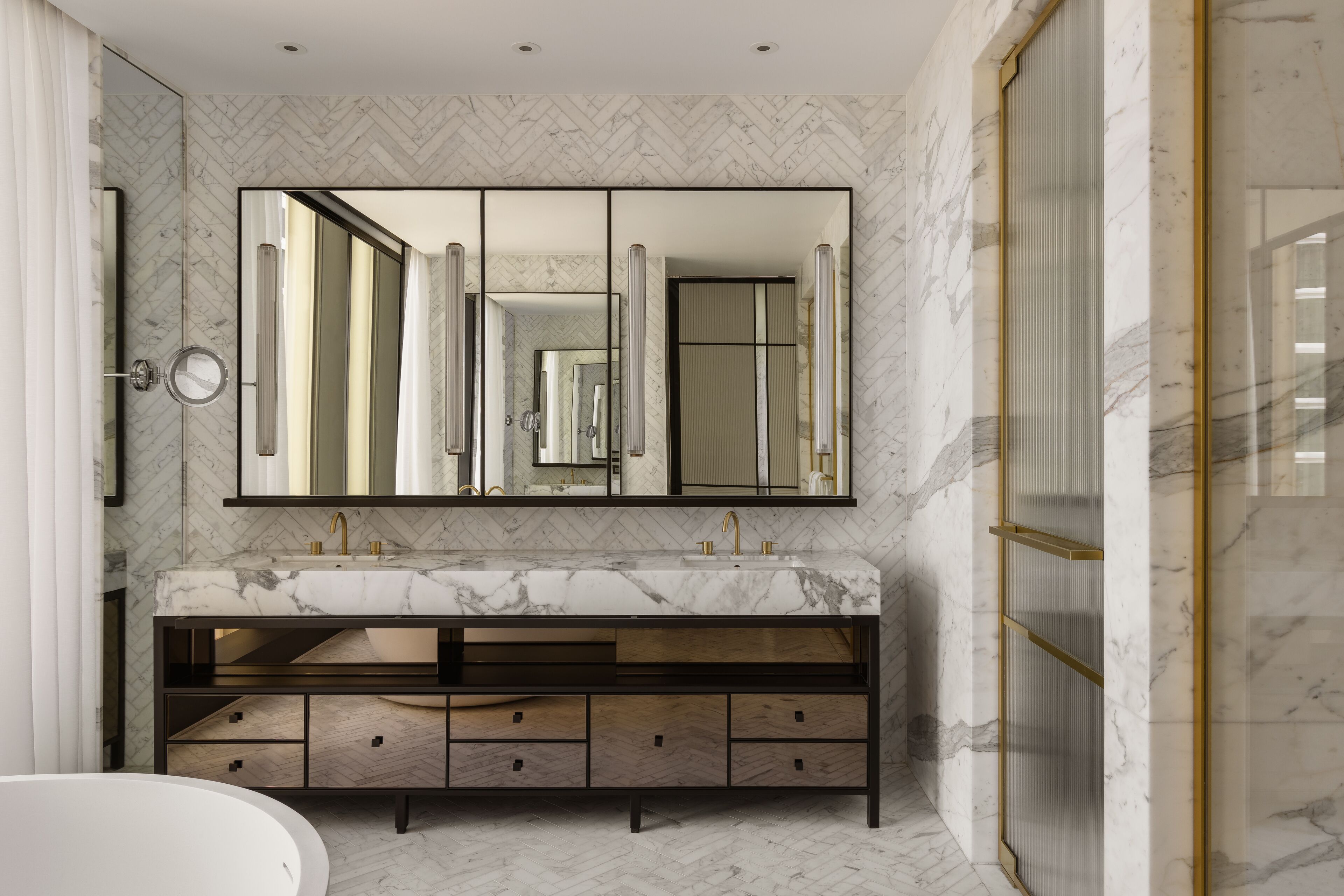 Une salle de bain moderne avec un lavabo en marbre, un grand miroir et une douche à l’italienne.