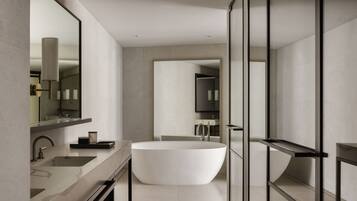 Un bagno moderno con una vasca freestanding, uno specchio ampio e un design minimalista.