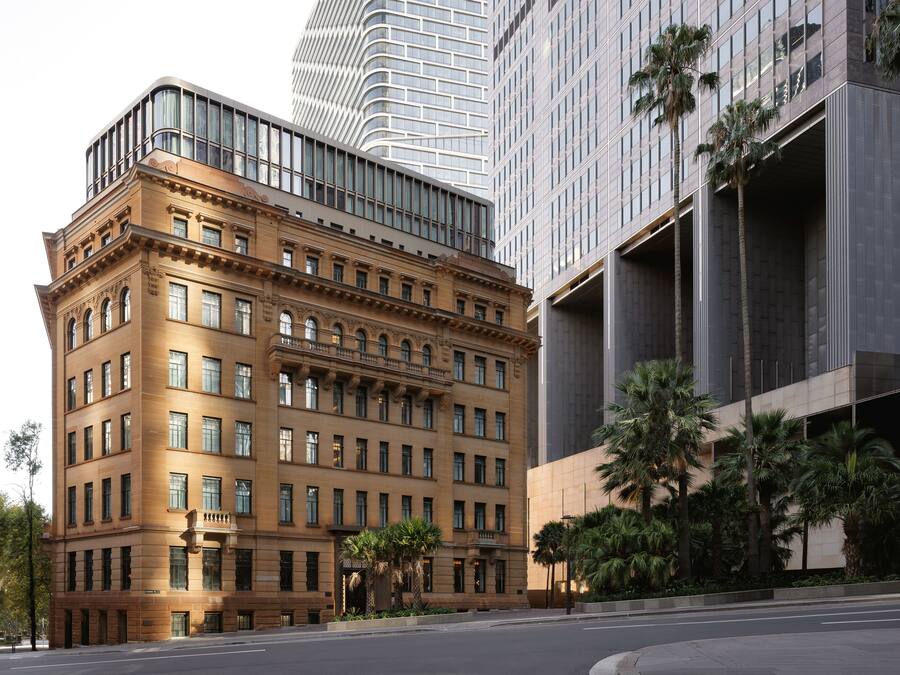 A multi-story building with a classical architectural style, featuring a prominent corner entrance and large windows.