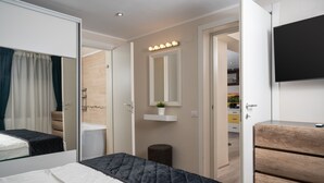 Un dormitorio con cama, cómoda, espejo y televisor.