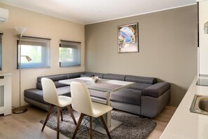 Appartement Deluxe | Coin séjour | TV connectée de 100 cm avec chaînes par c âble