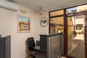 Ett receptionsområde med en receptionsdisk, stolar, en klocka och en världskarta på väggen.