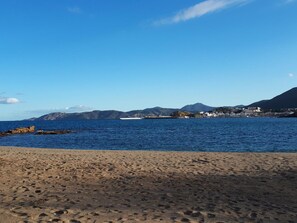 Una playa con vista despejada al mar y montañas distantes.