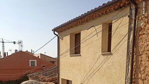 A rustic building with a stone facade, multiple windows, and a tiled roof. - RURAL HOUSE THE VIEWPOINT OF SAN MIGUEL (San Esteban de Gormaz)