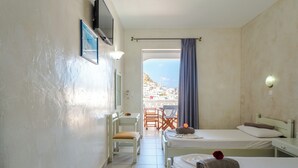 Habitación de hotel con dos camas, un escritorio, una silla y vistas a un pueblo costero.