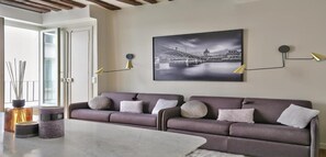 A modern living room with a sofa, two lamps, a coffee table, and a framed picture on the wall.