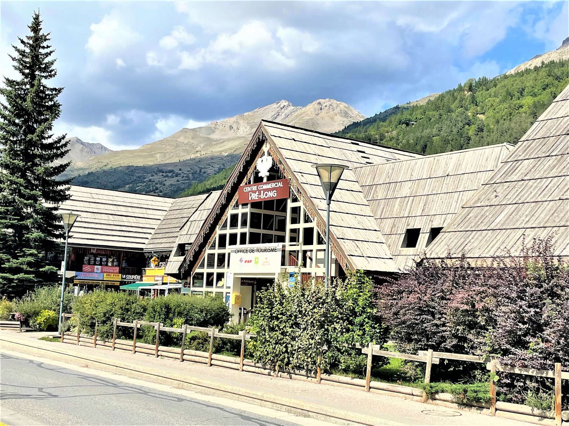 Un edificio de madera con un letrero que dice "Centre Commercial Pré-Long".