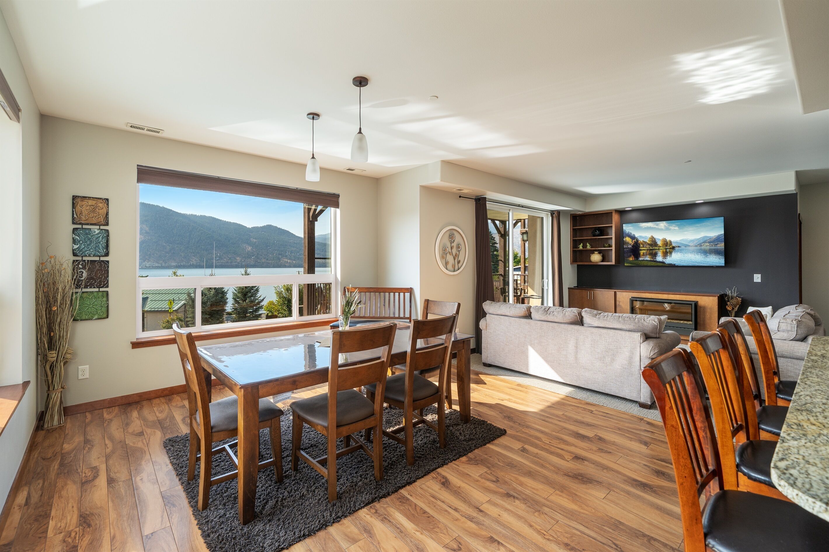 A spacious living area with a dining table, chairs, a sofa, and a TV.