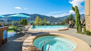 A pool area with a hot tub, lounge chairs, and a view of mountains. - Breathtaking views, walk downtown-Manson Bay (Manson)