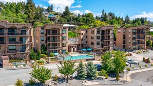 A multi-story hotel with a central pool, outdoor seating, and a landscaped garden. - Breathtaking views, walk downtown-Manson Bay (Manson)