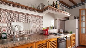 A kitchen with a granite countertop, stainless steel sink, and a red toaster. - Casa Mora + Caminito del Rey (Ardales, Malaga) (Ardales)