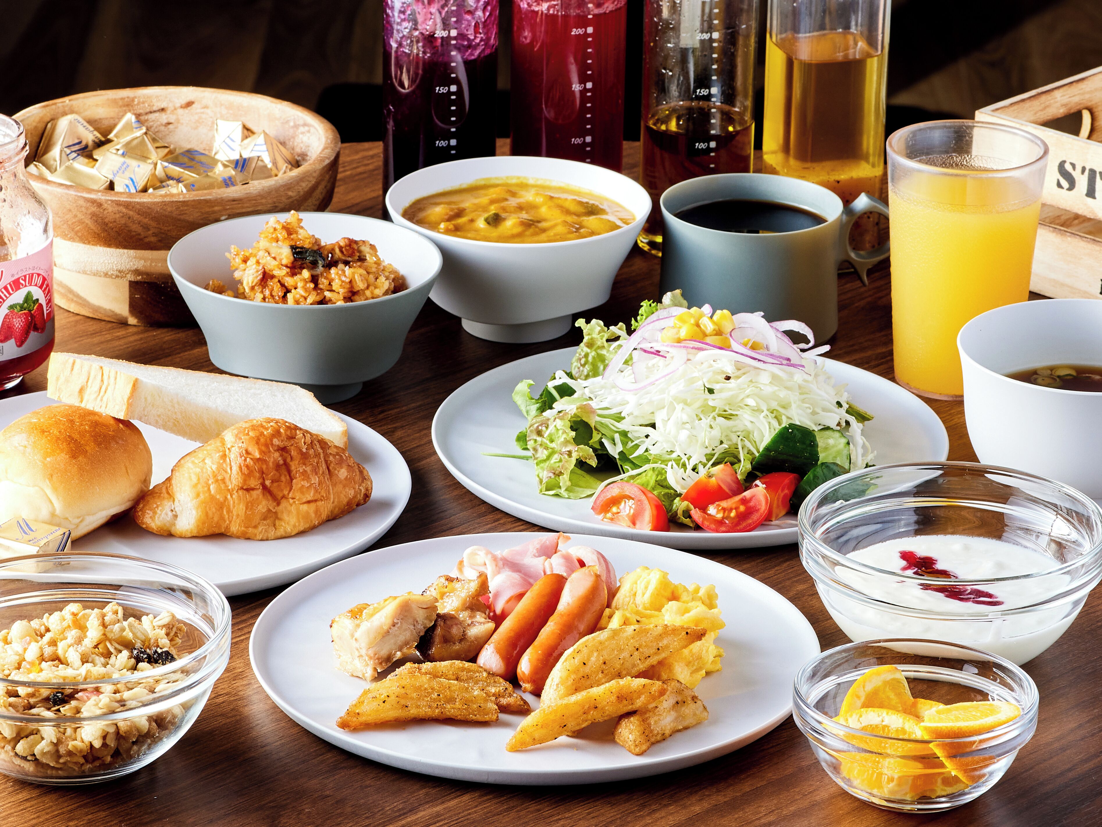 Een tafel met diverse soorten eten, zoals brood, salade en soep.