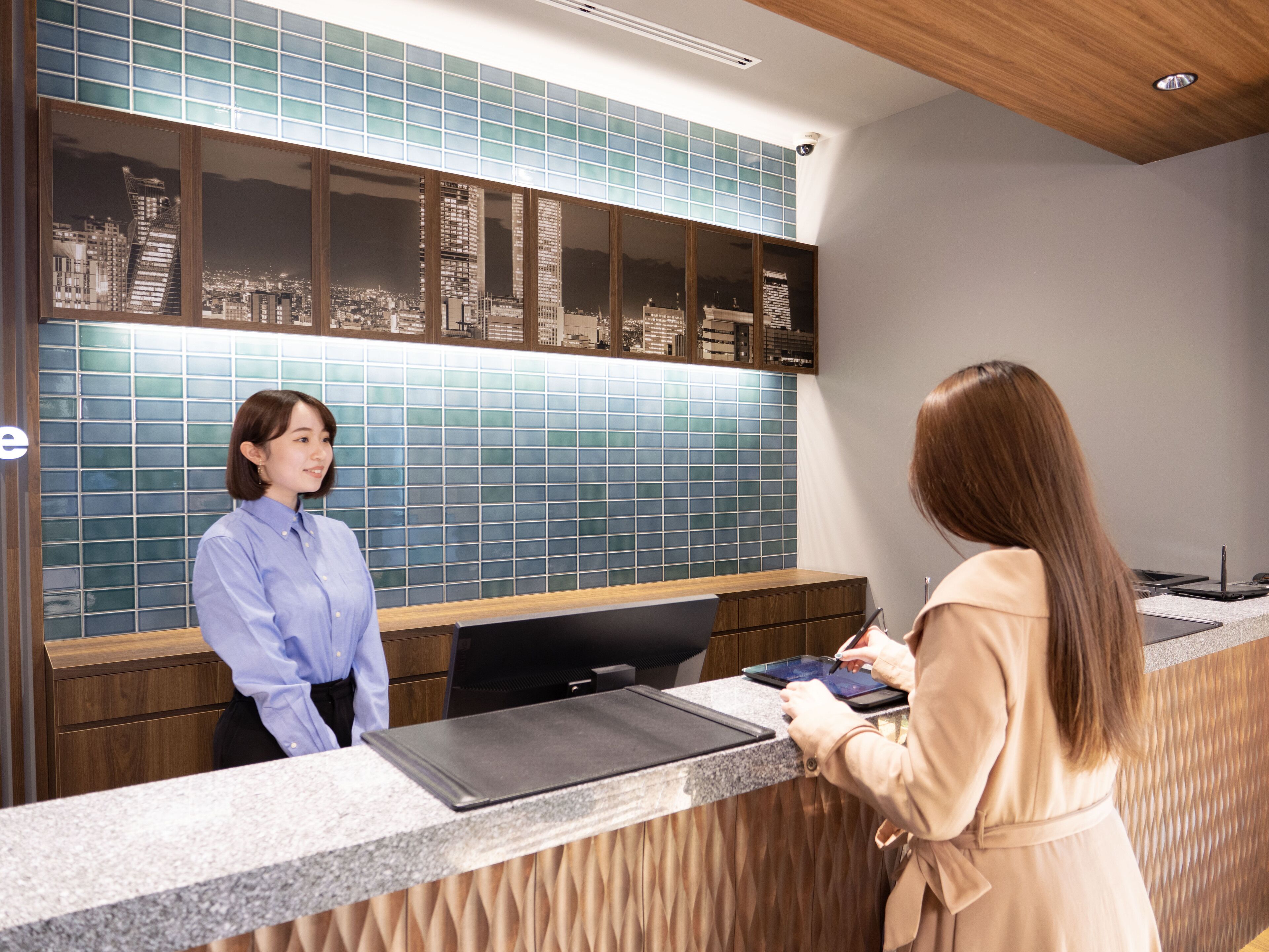 A reception desk with a cityscape view through the glass panels.