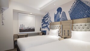 Een hotelkamer met twee bedden, een groot raam met uitzicht op de stad, en een muur met een stadslandschap-muurschildering.