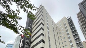 Een modern gebouw met een opvallende rode luifel en meerdere verdiepingen.