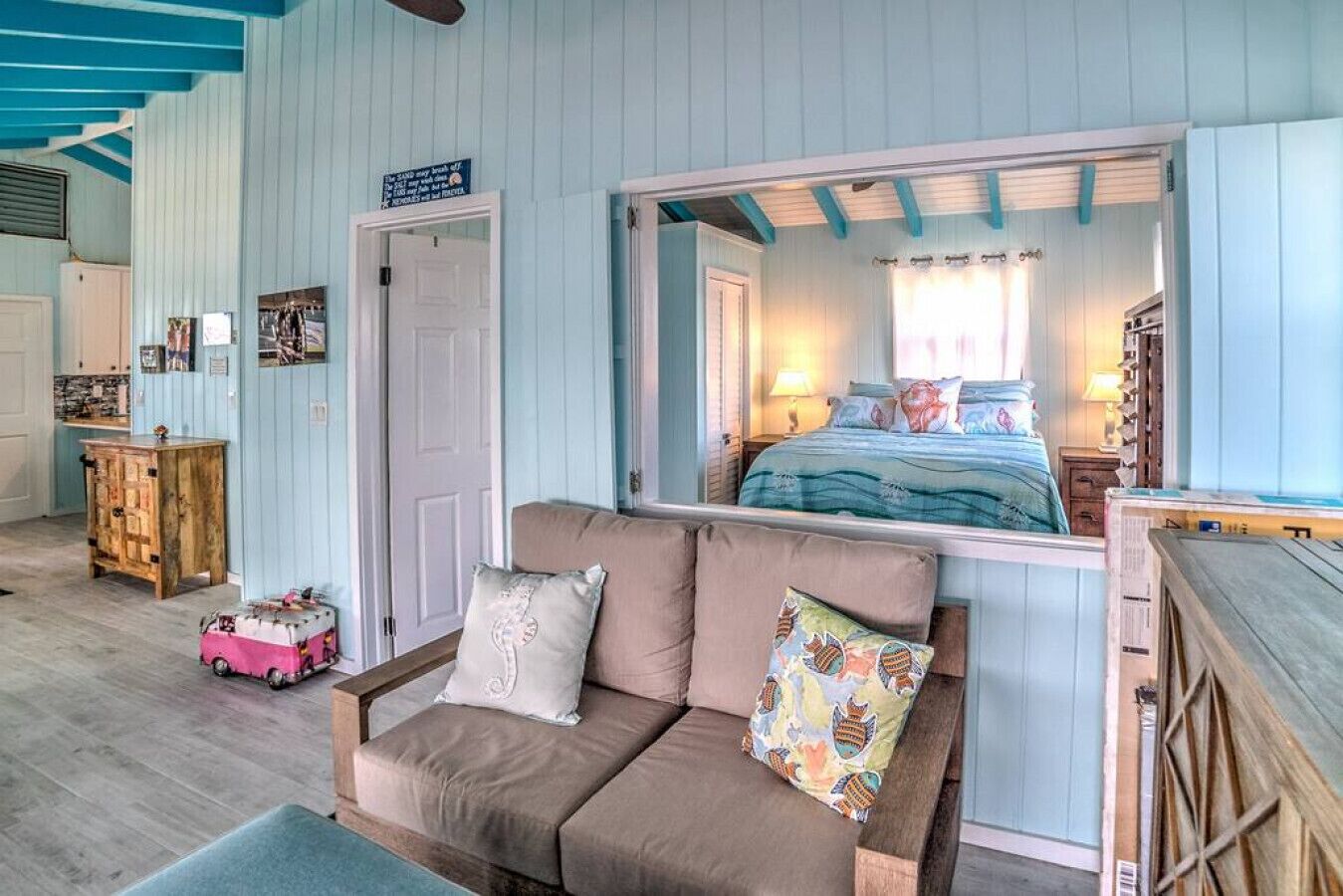 Una habitación acogedora con cama, sofá y un aparador de madera.