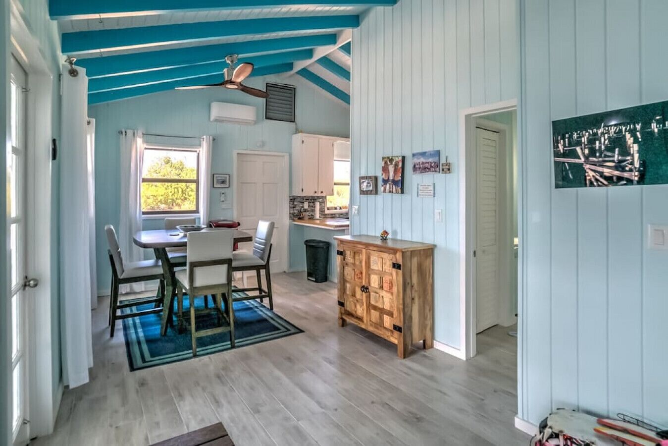 Una cocina amplia con zona de comedor, armarios de madera y ventilador de techo.