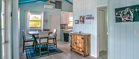 Una cocina amplia con zona de comedor, armarios de madera y ventilador de techo.