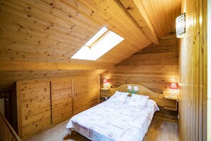 A cozy wooden cabin bedroom with a skylight, a bed with a patterned bedspread, and two bedside lamps. - Chalet for 9 people 300m from the Petit-Chatel chairlift - Chatel Reservation (Châtel)