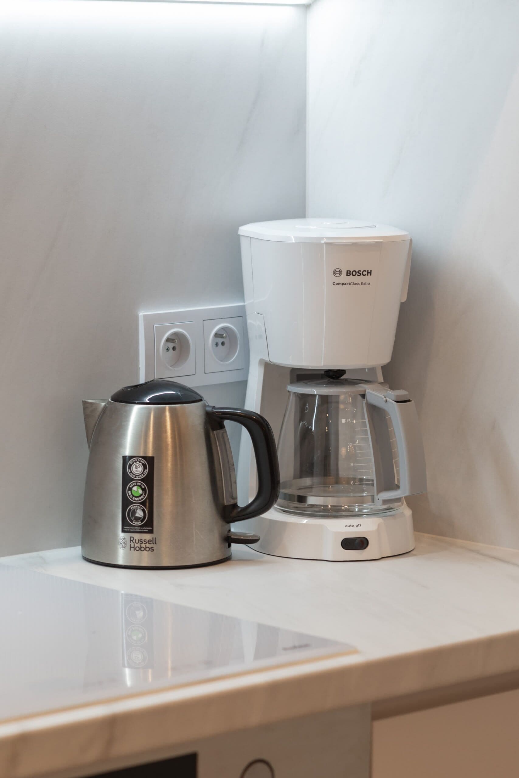 A kitchen counter with a Russell Hobbs kettle and a Bosch compact coffee maker.