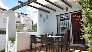 An outdoor patio with a table and chairs, a pergola, and a view of neighboring buildings. - House Pauline 3 Bed. Poolside, Private Garden. M-5 (Marbella)