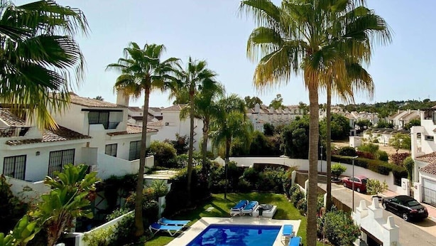 A resort with a swimming pool, palm trees, and white buildings. - House Pauline 3 Bed. Poolside, Private Garden. M-5 (Marbella)
