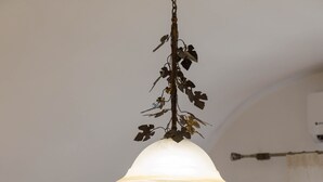 Een hotelkamer met een bed, een aan de muur bevestigde televisie en een hanglamp.