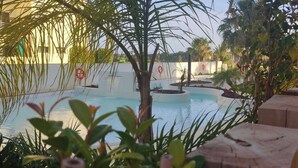 A pool area with palm trees and a lifebuoy. - Comfort and exclusivity on the tropical coast (Motril)