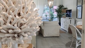 A modern living room with a large white sculpture, a sofa, a TV, and a dining area. - Comfort and exclusivity on the tropical coast (Motril)