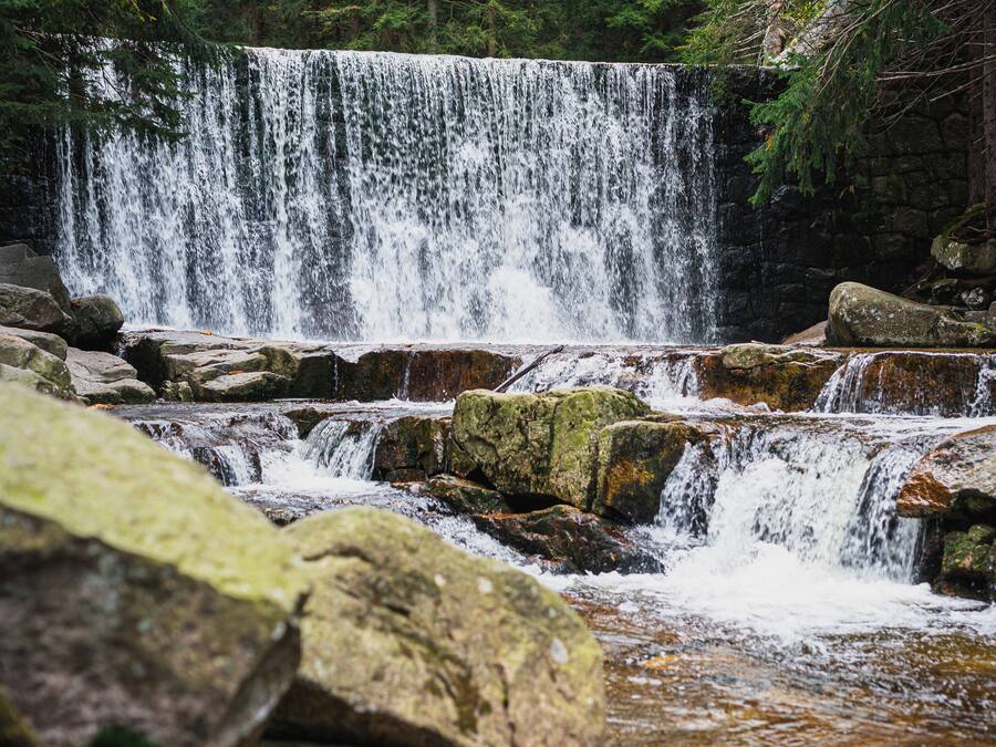 A waterfall cascading over rocks in a forested area.