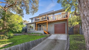 A two-story house with a front porch, a garage, and a well-maintained lawn.