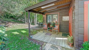 Eine Holzhütte mit Veranda, zwei Schaukelstühlen und einem Willkommen-Schild.