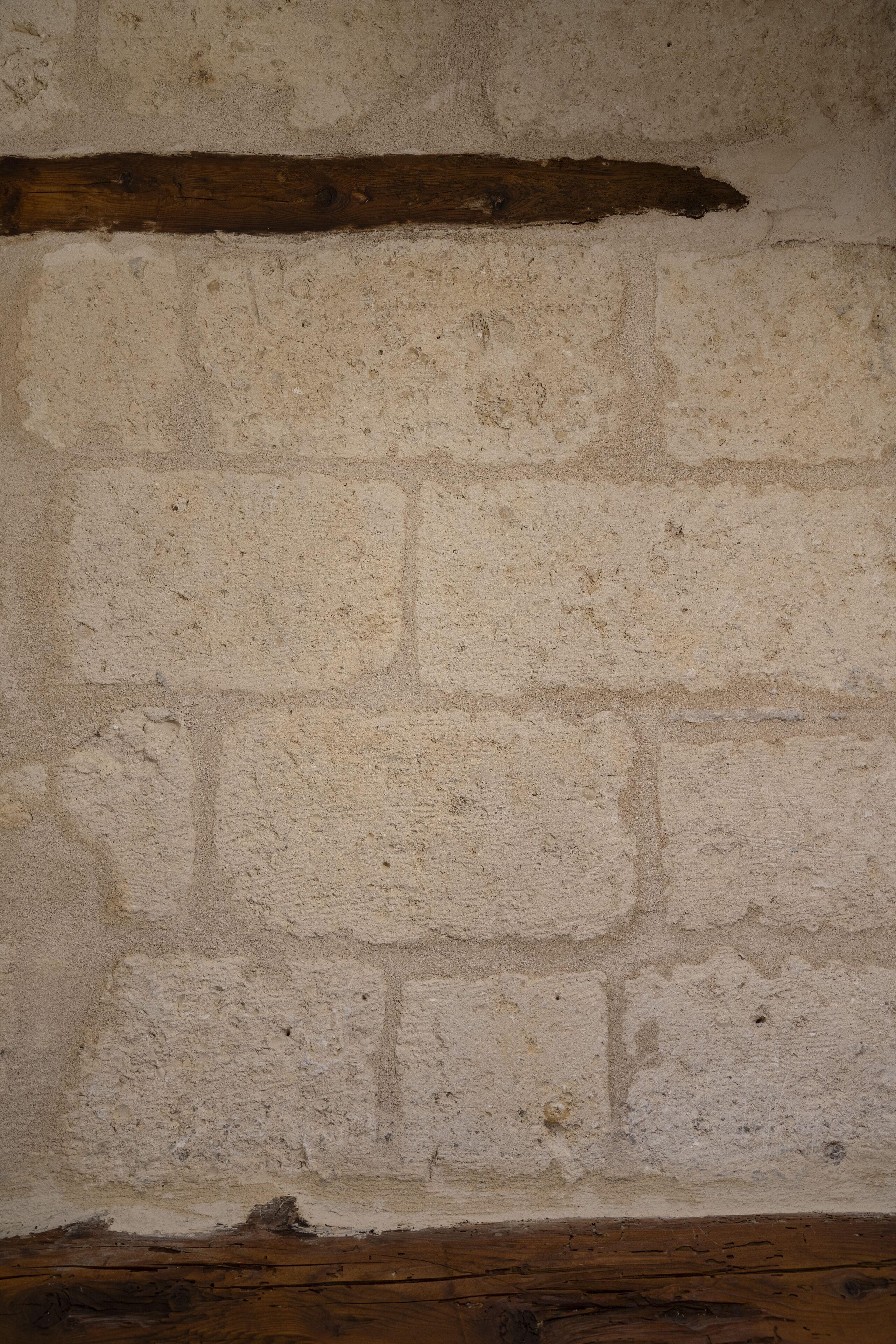 A textured wall with a wooden beam.