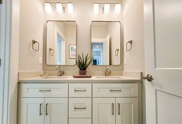 A bathroom with two sinks, a mirror above each, and a potted plant on the countertop. - Gone Coastal: A Paws-itively Perfect Beach Escape! (Surf City)
