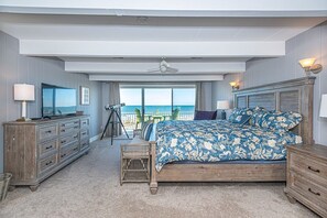 A bedroom with a large bed, a dresser, a television, and a balcony with a view of the ocean. - Comfy, spacious 3 bedroom oceanfront townhouse with free WiFi and breathtaking ocean views located downtown just steps from the beach! (Ocean City)