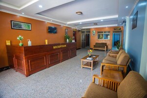 Zona de recepción con un mostrador de madera identificado con la leyenda 