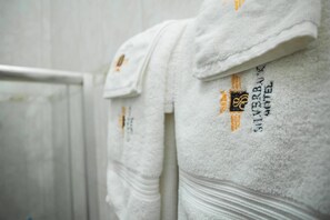 A row of neatly folded white towels with a logo and text indicating they are from the Silver Blaze Hotel. - Silverback Hotel (Mbarara)