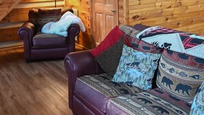Un intérieur en bois avec un escalier, un canapé et un fauteuil.