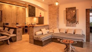 A modern interior with a wooden accent wall, a stone pillar, and a large abstract painting. - Villa in Nature (Vila do Porto)